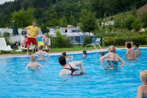 Vacaciones en Camping Bella Austria: familias y niños disfrutando de la piscina al aire libre.