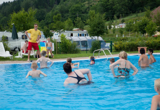 Vakantie op Camping Bella Austria: gezinnen en kinderen zwemmen en spelen in een buitenzwembad.