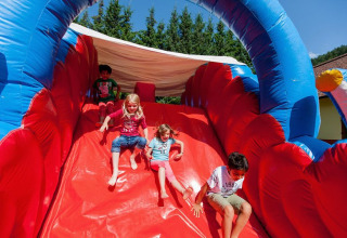 Bambini che scivolano su uno scivolo gonfiabile al Camping Bella Austria in Stiria, Austria.