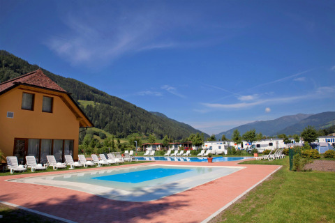 Piscine extérieure avec transats et vue sur les montagnes au Camping Bella Austria, Styrie, Autriche.