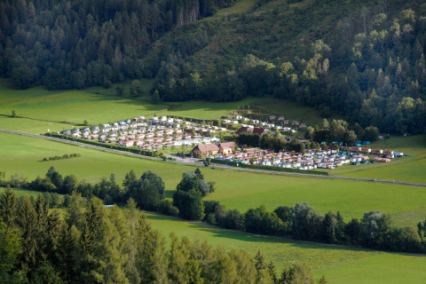 Vista aérea del Camping Bella Austria, un parque vacacional rodeado de campos verdes y bosques en Estiria, Austria.