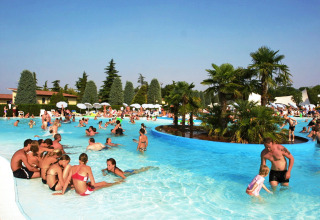 Folk nyder en livlig dag ved swimmingpoolen i Camping Bella Italia, feriepark i Veneto, Italien.