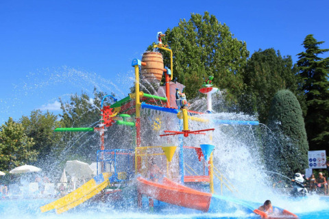 Parco giochi acquatico colorato con scivoli e fontane al Camping Bella Italia, Veneto, Italia.