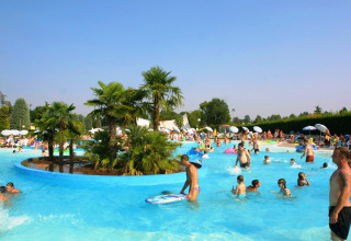 Folk nyder en solrig dag i swimmingpoolen på Camping Bella Italia-ferieparken i Veneto, Italien.