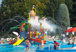 Children and families play in a colorful water park with slides at Camping Bella Italia in Veneto, Italy.