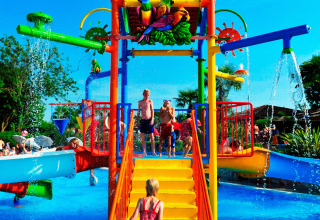 Children playing on a colorful water playground at Camping Bella Italia, Veneto, Italy, on a sunny day.