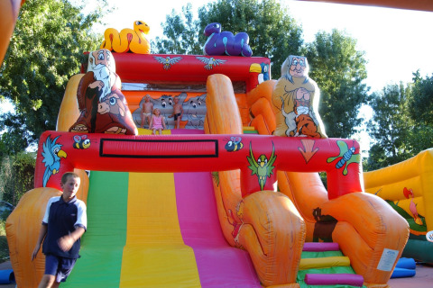 Bambini che giocano su uno scivolo gonfiabile colorato al Camping Bella Italia, villaggio turistico in Veneto, Italia.