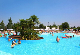 People enjoying a sunny day at the pool in Camping Bella Italia holiday park in Veneto, Italy.