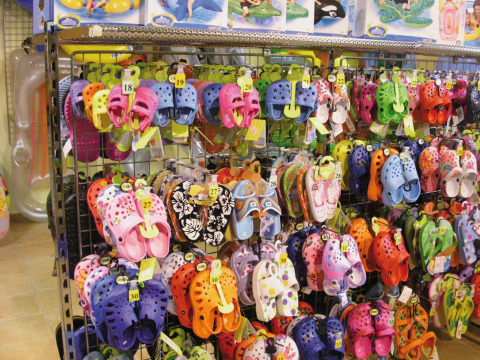 Sandalias y chanclas coloridas en un expositor de una tienda en Camping Bella Italia, Véneto, Italia.