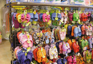 Colorful sandals and flip-flops displayed on a rack at a shop in Camping Bella Italia, Veneto, Italy.
