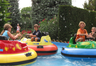 Bambini si divertono sulle barche autoscontro colorate al Camping Bella Italia, Veneto, Italia, tra bolle.