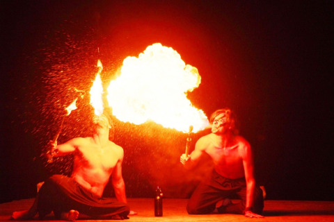 Dos artistas realizan un espectáculo de escupir fuego en Camping Bella Italia, Véneto, Italia, de noche con llamas.