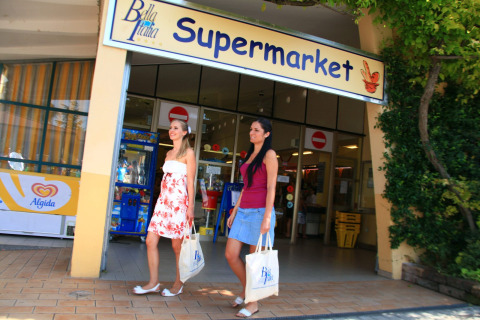 Due donne escono da un supermercato al Camping Bella Italia, un villaggio turistico in Veneto, Italia.