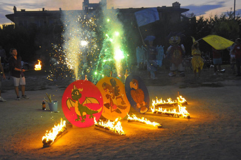 Fuochi d'artificio, fuoco e mascotte durante una serata al Camping Bella Italia, nel Veneto, Italia.