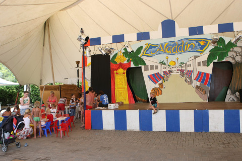 Enfants et familles participent à des activités devant une scène Aladdin au Camping Bella Italia, Vénétie, Italie.