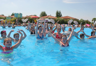 Children enjoy swimming and playing games in the pool at Camping Bella Italia holiday park in Veneto, Italy.