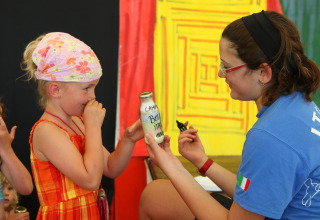 Una donna mostra una bottiglia a una bambina a Camping Bella Italia, un villaggio vacanze in Veneto.