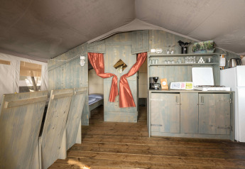 Interior de la tienda Safari Tent Luxury en Koversada Camping Resort, Croacia, con cocina y dormitorio.