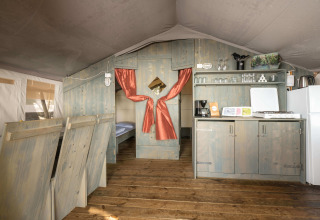 Interieur van de Safari Tent Luxury op Koversada Camping Resort in Kroatië met keuken en slaapgedeelte.