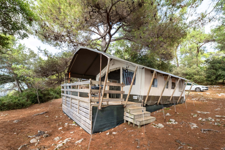 Safari Tent Luxury bij Koversada Camping Resort in Kroatië, omgeven door dennenbomen en natuur.