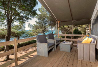 Houten veranda met comfortabele stoelen en uitzicht op zee bij Safari Tent Luxury, Koversada Camping Resort, Kroatië.