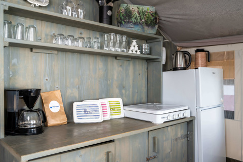 Kitchen area of a Safari Tent Luxury at Koversada Camping Resort in Croatia, showing appliances and utensils.