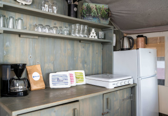 Área de cocina en una Safari Tent Luxury del Koversada Camping Resort en Croacia, con electrodomésticos y utensilios.