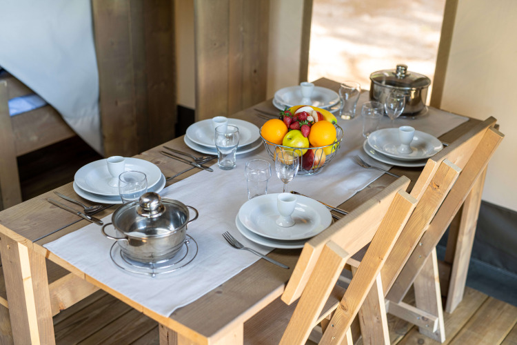 Set dining table in a safari tent with fruit bowl and pots, Camping Krk, Croatia, Comfort tent with air conditioning.