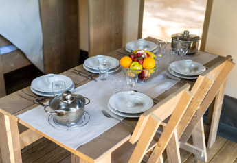 Gedeckter Holztisch im Safari-Zelt mit Obstschale und Töpfen, Camping Krk, Kroatien, Comfort-Zelt mit Klimaanlage.