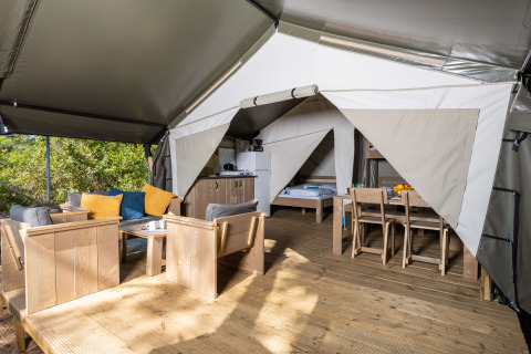 Vista interior de la tienda Safari Comfort con aire acondicionado, muebles modernos y terraza en Camping Krk.