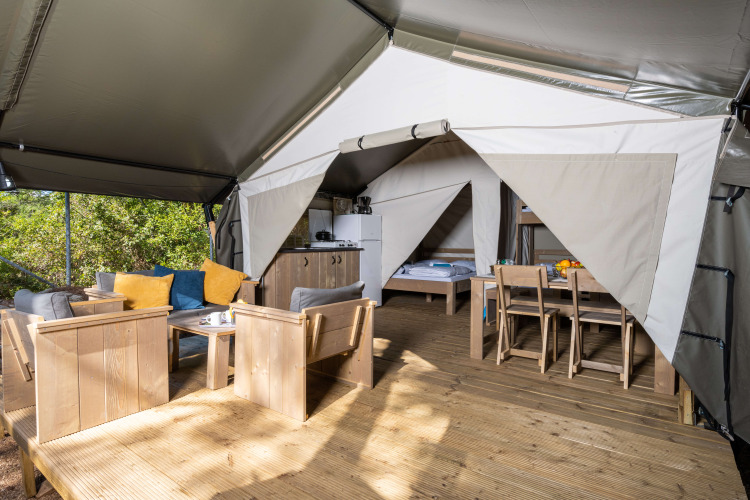Binnenaanzicht van de Safari tent Comfort met airconditioning, modern meubilair en terras op Camping Krk.