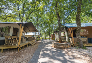 Tende safari con servizi igienici al Camping Aminess Maravea in Croazia, immerse tra alberi e vialetti.