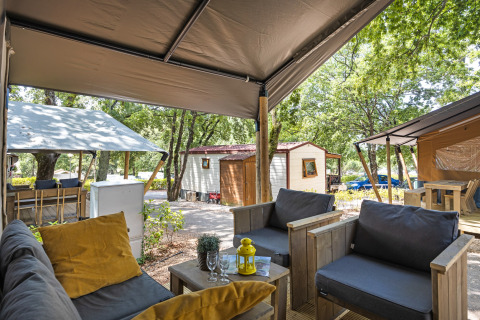 Vista da una tenda safari con servizi igienici al Camping Aminess Maravea, Croazia, con area salotto accogliente.