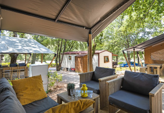Vista da una tenda safari con servizi igienici al Camping Aminess Maravea, Croazia, con area salotto accogliente.