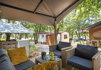 Vista da una tenda safari con servizi igienici al Camping Aminess Maravea, Croazia, con area salotto accogliente.