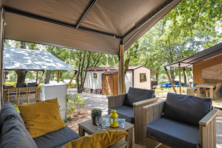 Vista desde una tienda safari con instalaciones sanitarias en Camping Aminess Maravea, Croacia, con asientos cómodos.