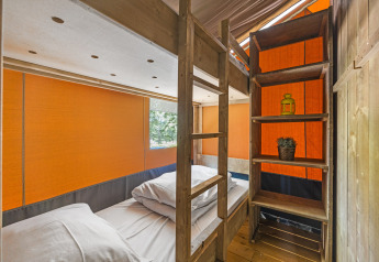 Binnenaanzicht van safaritent met stapelbed en houten planken bij Camping Aminess Maravea in Kroatië.