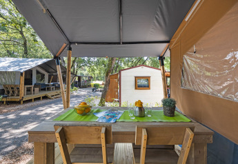 Safari tent met eigen sanitair op Camping Aminess Maravea in Kroatië, buiteneettafel met houten stoelen.