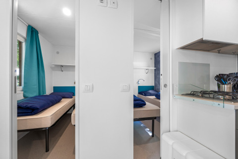 Intérieur du Mobile home Funtana au Camping Bijela Uvala en Croatie, avec deux chambres et une cuisine.