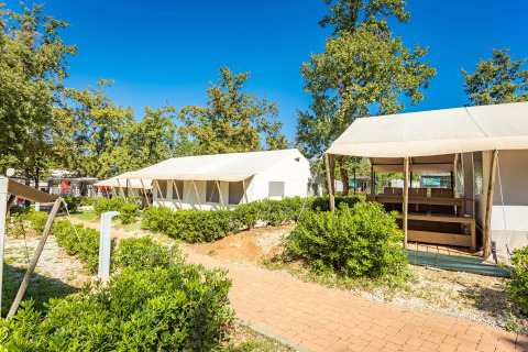 Safari-telte med sanitære faciliteter på Camping Bijela Uvala i Kroatien, omgivet af grønt og solrigt vejr.
