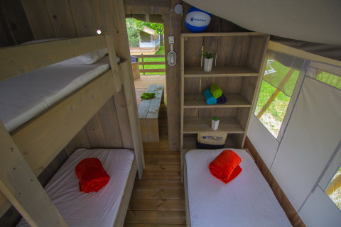 Vista interna della Safari Tent Luxury al Camping Krk in Croazia con letti a castello e singoli.