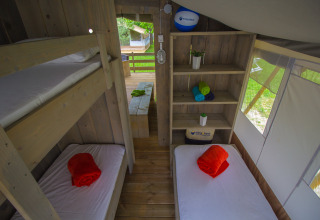 Vista interna della Safari Tent Luxury al Camping Krk in Croazia con letti a castello e singoli.