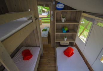 Vista interna della Safari Tent Luxury al Camping Krk in Croazia con letti a castello e singoli.