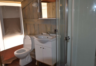 Baño dentro de tienda safari con inodoro, lavabo y ducha en Camping Polari en Croacia.