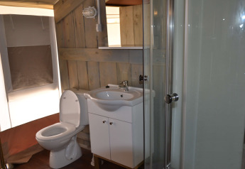 Bathroom inside a safari tent with toilet, sink, and shower at Camping Polari in Croatia.