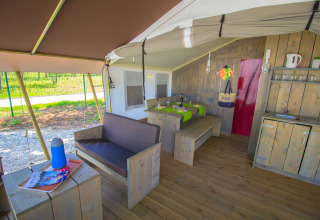 Interior de tienda safari con asientos, comedor, cocina y aire acondicionado en Camping Polari, Croacia.
