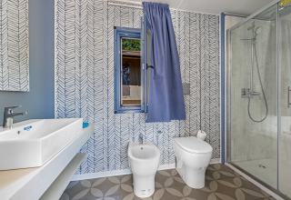 Salle de bain moderne de Mobile home Pula au Camping Bijela Uvala en Croatie avec douche, WC et bidet.