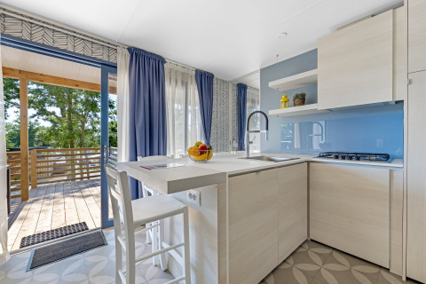 Cuisine moderne et lumineuse d’un mobil-home au Camping Bijela Uvala en Croatie, avec accès terrasse.