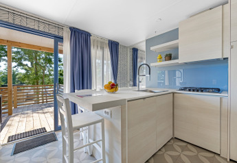 Cuisine moderne et lumineuse d’un mobil-home au Camping Bijela Uvala en Croatie, avec accès terrasse.