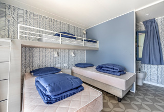 Schlafzimmer im Mobile Home Pula im Camping Bijela Uvala, Kroatien, mit drei Betten und modernem Design.